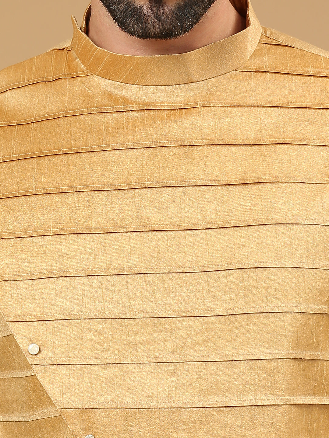 Close-up of a mustard yellow textured kurta with horizontal pleats and a high mandarin collar, worn by a man.