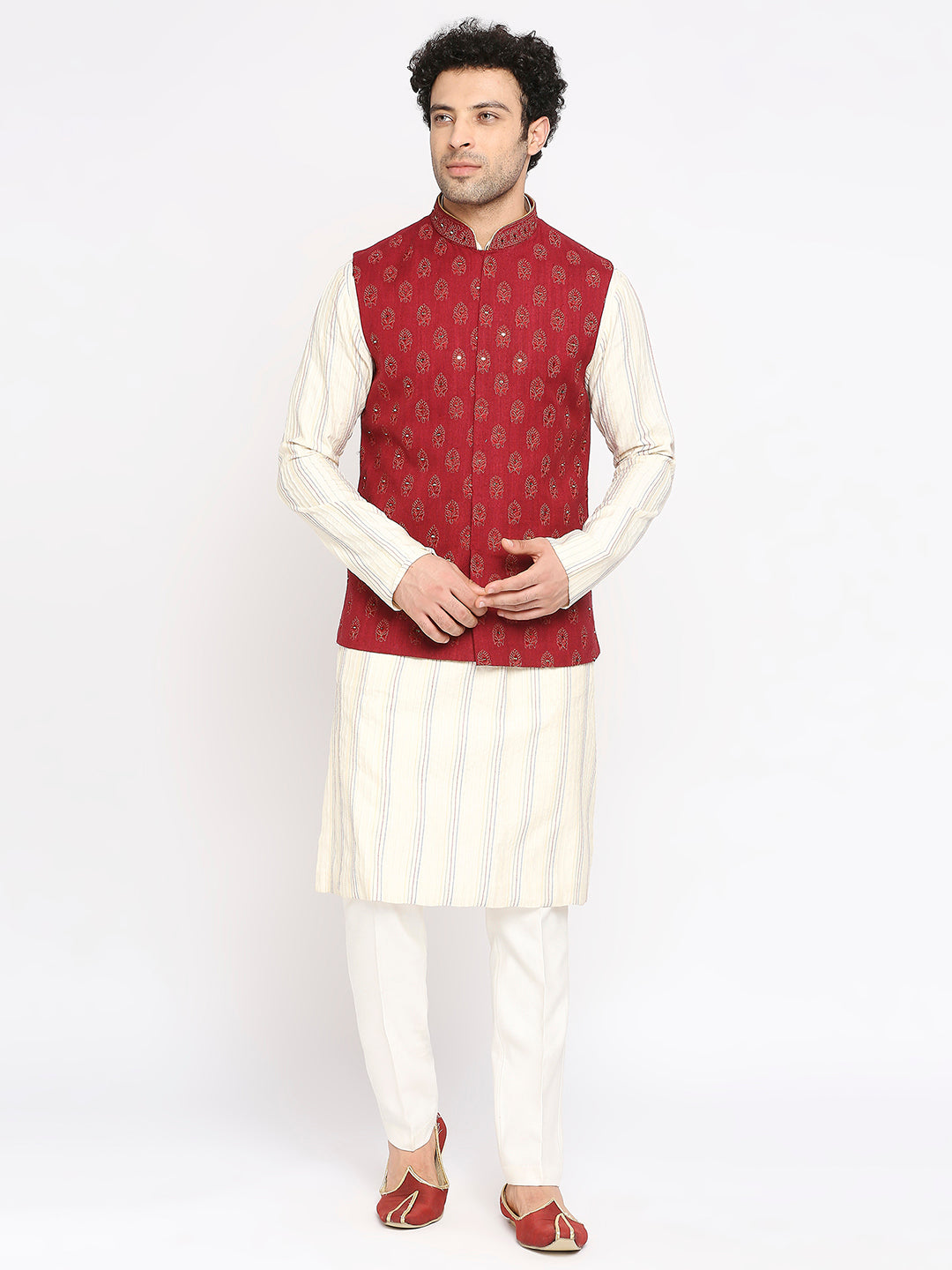 Featuring a maroon jacket with mirror-embroidered motifs, paired with an off-white kurta with multicolored thread work and Aligarhi pants—designed to stand out at wedding events.